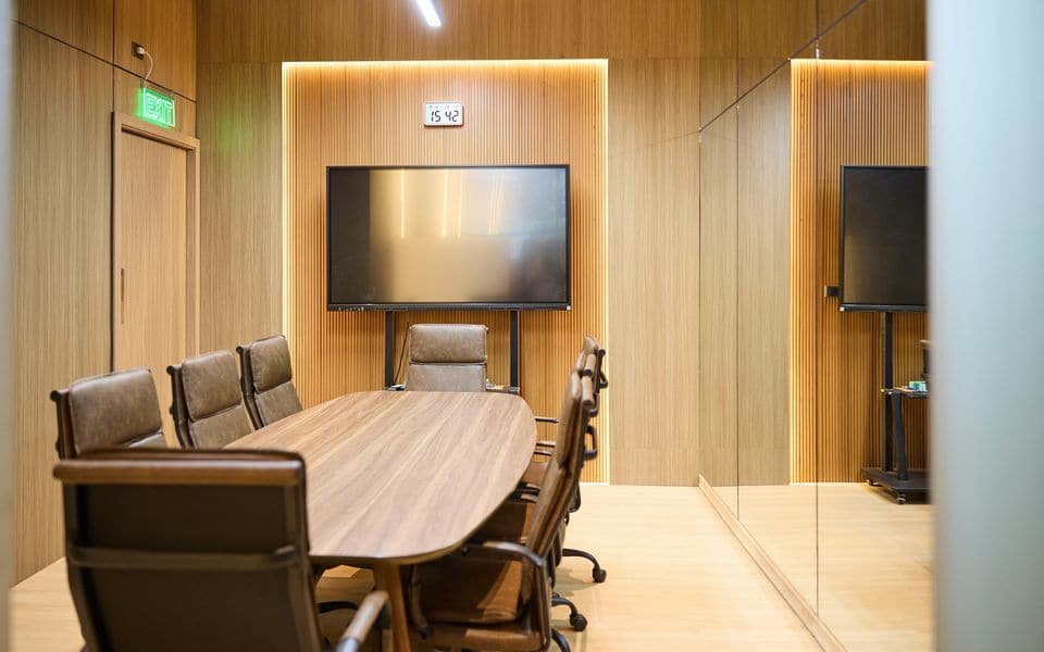Executive boardroom with an oval conference table and presentation display