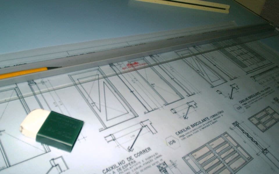 Printed architectural drawings on a drafting table